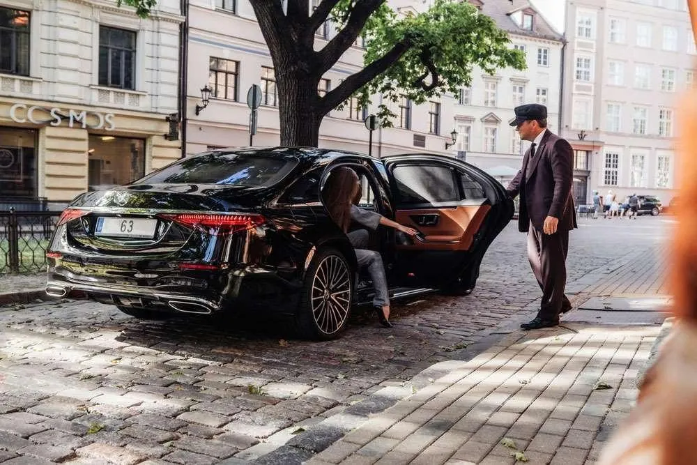 Chauffeur beside a black car in Dallas–Fort Worth