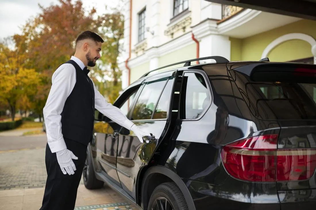 White-glove chauffeur opening a luxury SUV door