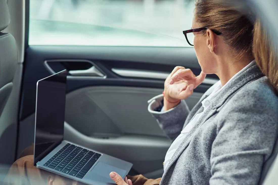 Executive working in the back seat during a Dallas corporate car service transfer