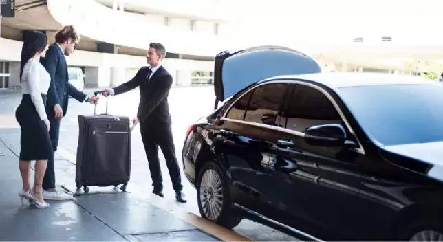 Chauffeur loading luggage for a DFW airport cab ride