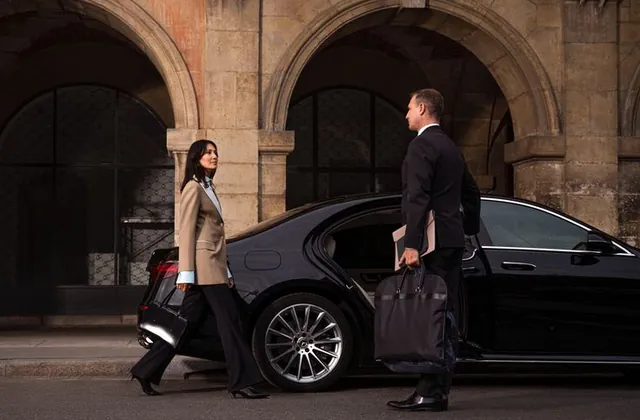 Executive met by a chauffeur at a black car for a Dallas airport transfer
