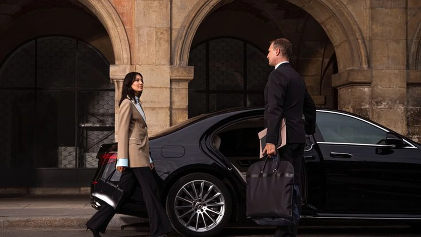 Executive being met by a chauffeur at a black Mercedes-Benz S-Class for a Dallas airport transfer